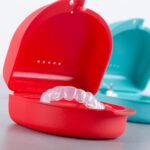 A bright red case showing a clear aligner.